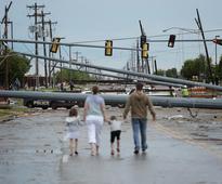 MOORE, OK - MAY 21: Downed utility poles block the road as a family walks south on Sante Fe Avenue at SW 19th Street after yesterday's deadly tornado on May 21, 2013 in Moore, Oklahoma.