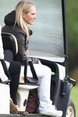Zara Phillips steals a quick kiss with husband Mike Tindall as he plays charity golf game