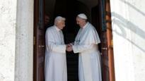 Pope Francis greets Benedict on his return